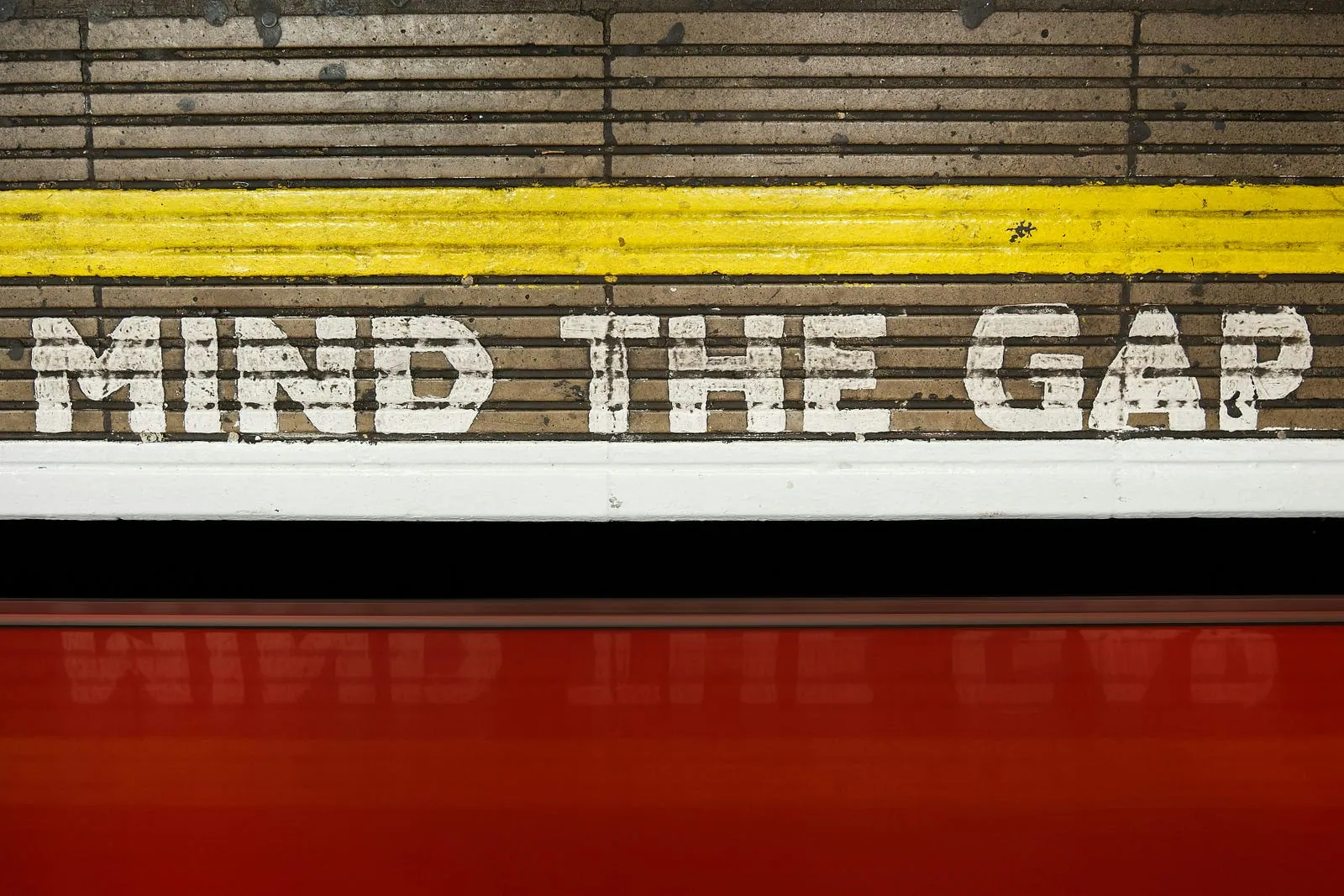 “Mind the gap” painted along the edge of a railway platform.