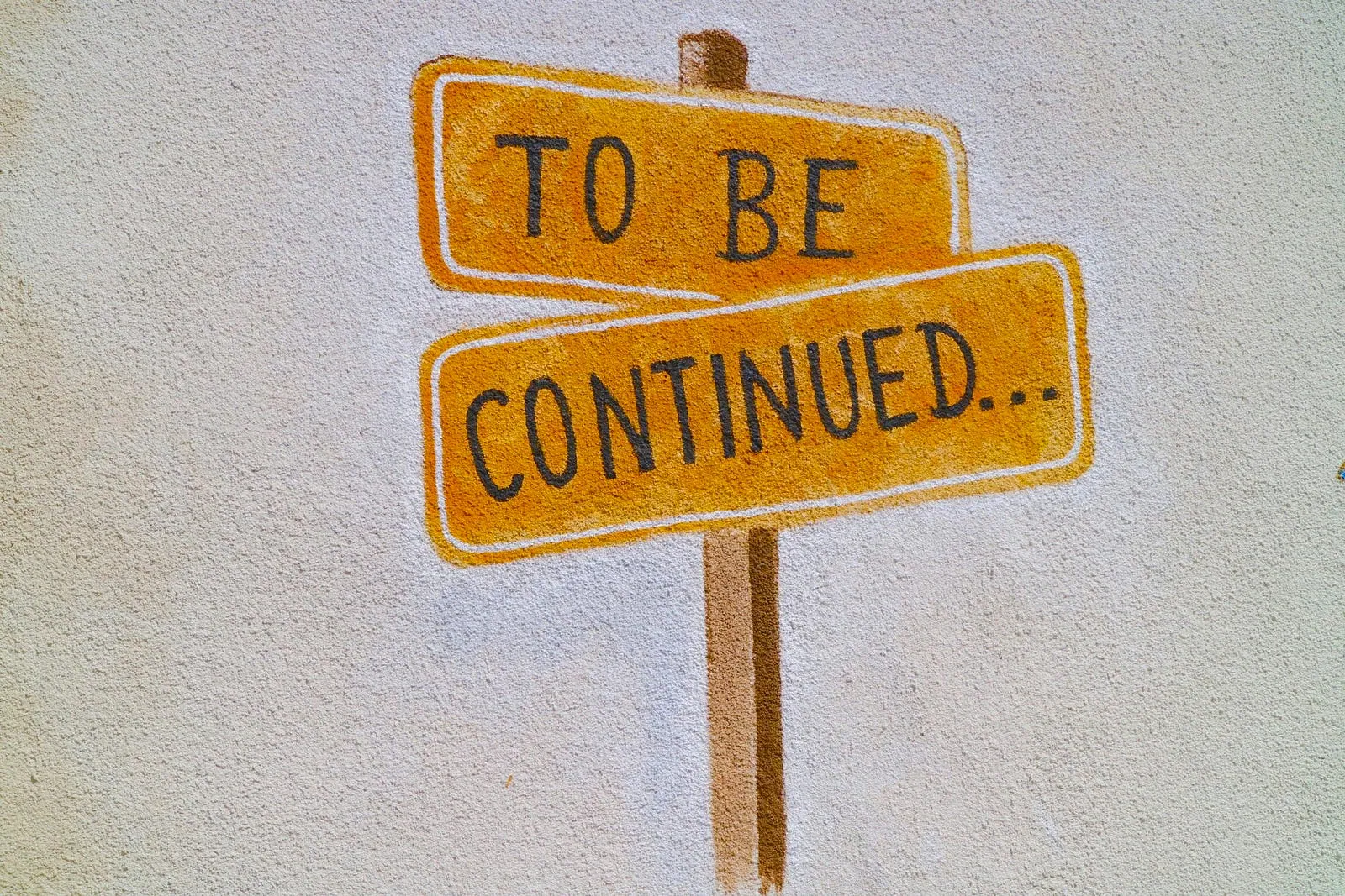 A painted signpost reading “To be continued…”.