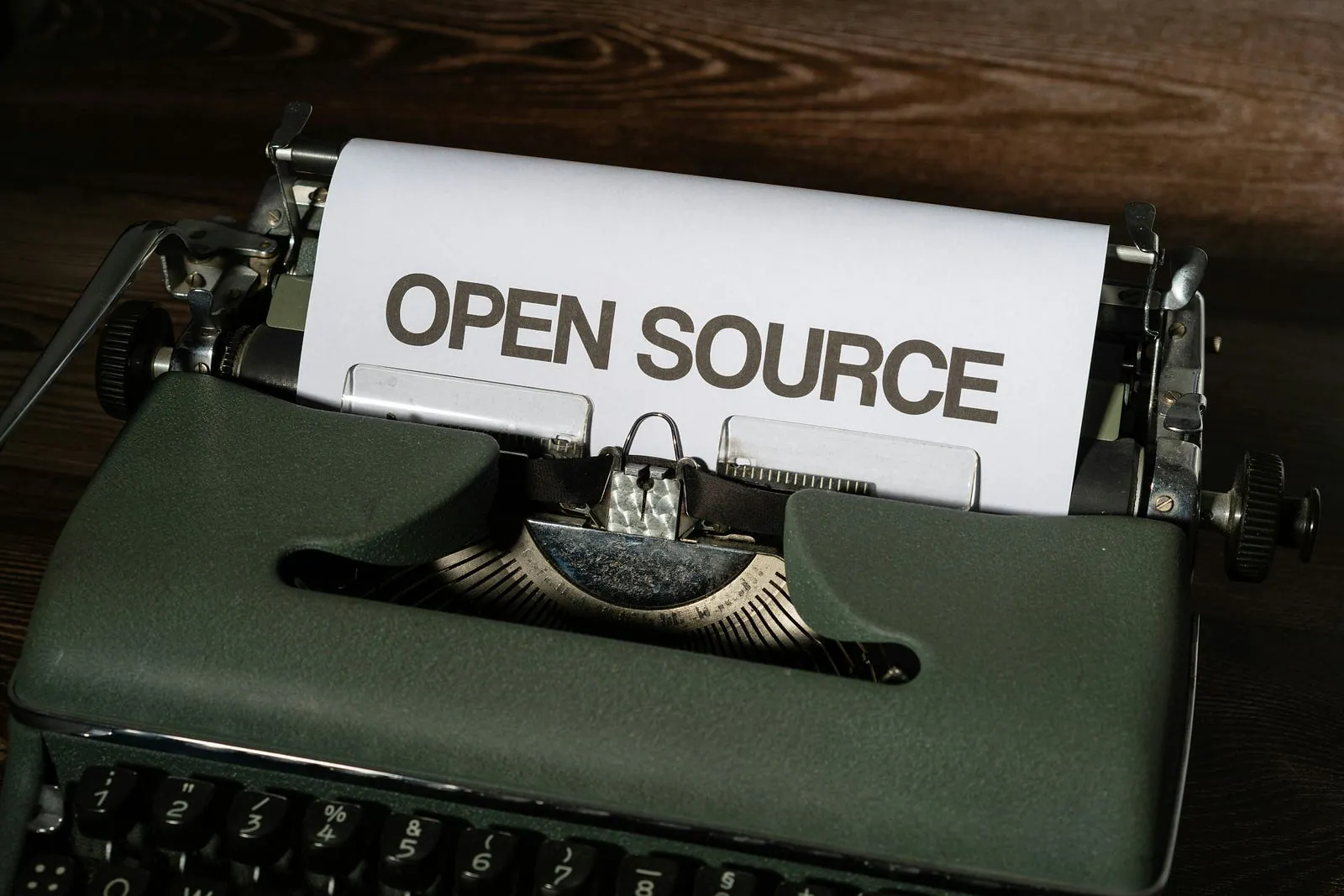A typewriter with a sheet of paper reading “Open Source”.